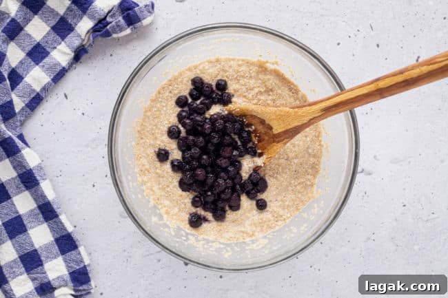 Blueberry Oat Bran Muffins — Flourless, Sugar-Free Recipe 6 Stirring oat bran muffin batter with blueberries.