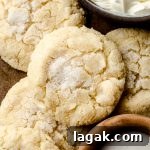 Cream Cheese Drop Cookies – Soft, Sugar Coated Treats 15 Aerial photo of cream cheese sugar cookies on a surface with a small bowl of sugar and a bowl of cream cheese.