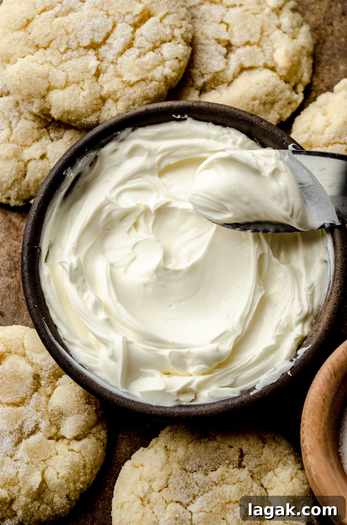 Cream Cheese Drop Cookies – Soft, Sugar Coated Treats 3 Aerial photo of a bowl of cream cheese with a spreader and sugar cookies around it.