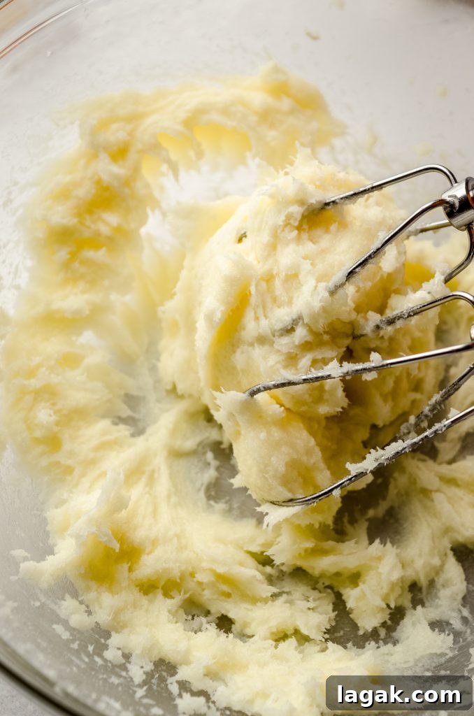 Cream Cheese Drop Cookies – Soft, Sugar Coated Treats 6 A bowl of cream cheese sugar cookie dough with electric beaters.