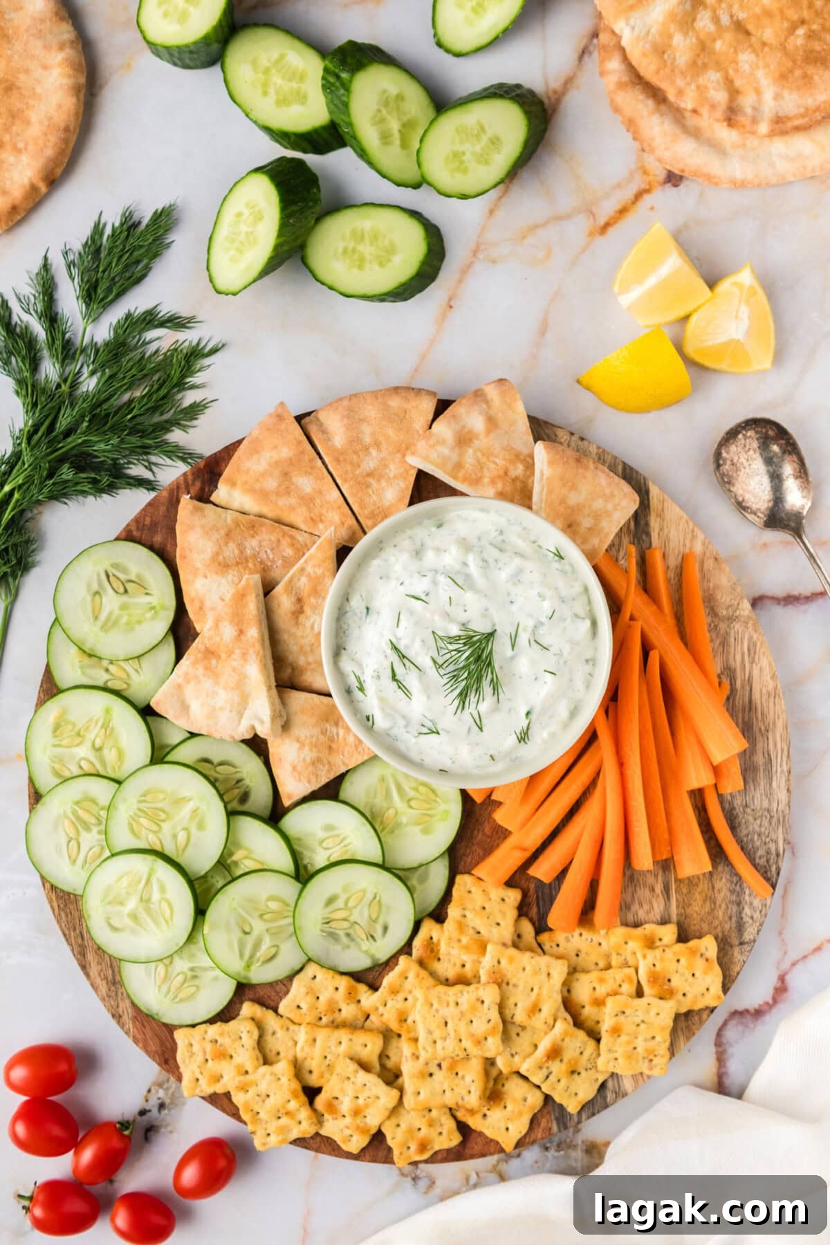Authentic Greek Tzatziki Sauce Recipe — Creamy Cucumber Yogurt Dip 2 Tzatziki Sauce in a bowl on a platter with pita bread, crackers, carrots and cucumbers