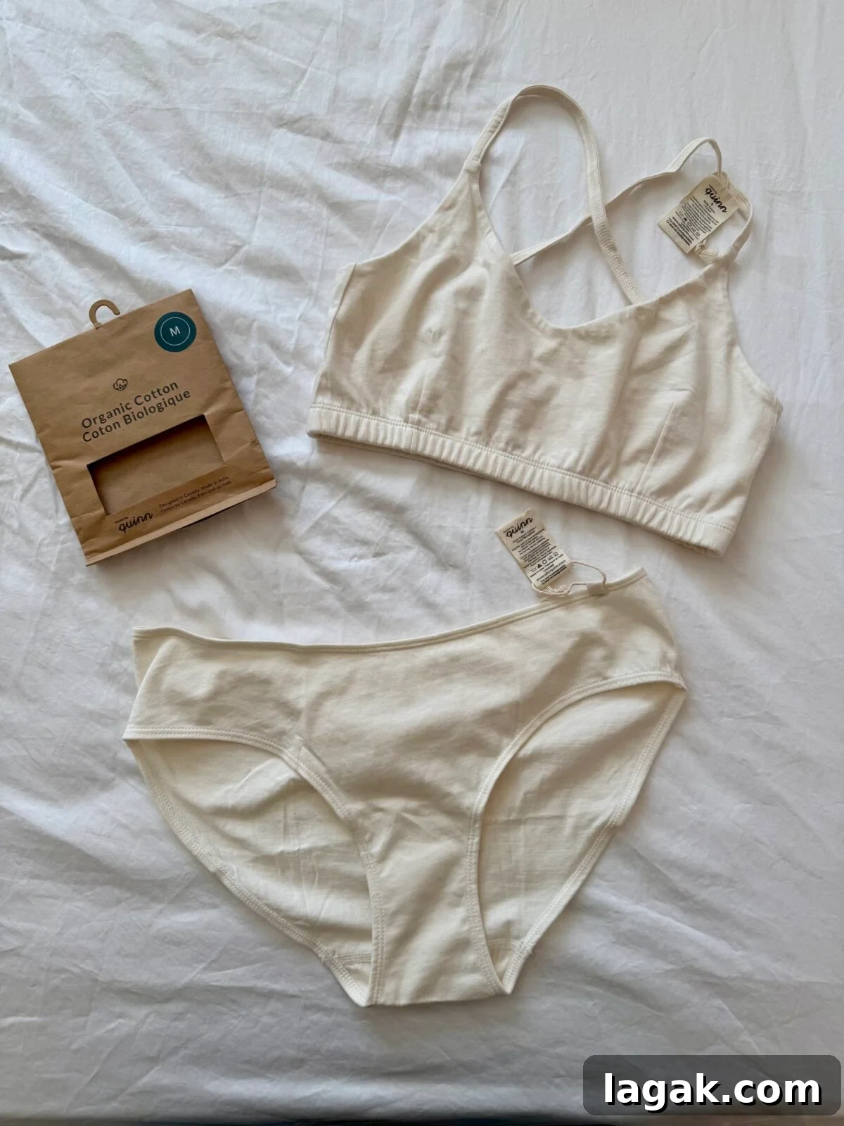 Underwear Brands for Sensitive Skin: Top Picks for Adults & Kids 6 A matching set of off-white organic cotton underwear, consisting of a bralette and a pair of briefs, is laid out on a white surface. Tags are attached, and packaging is placed on the left.