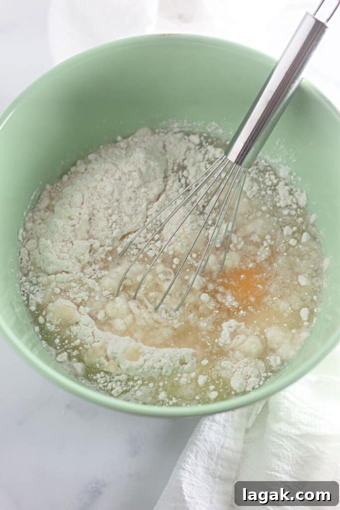 Moist Maraschino Cherry Cake Recipe with Cherry Glaze 6 Batter being mixed in a green bowl.