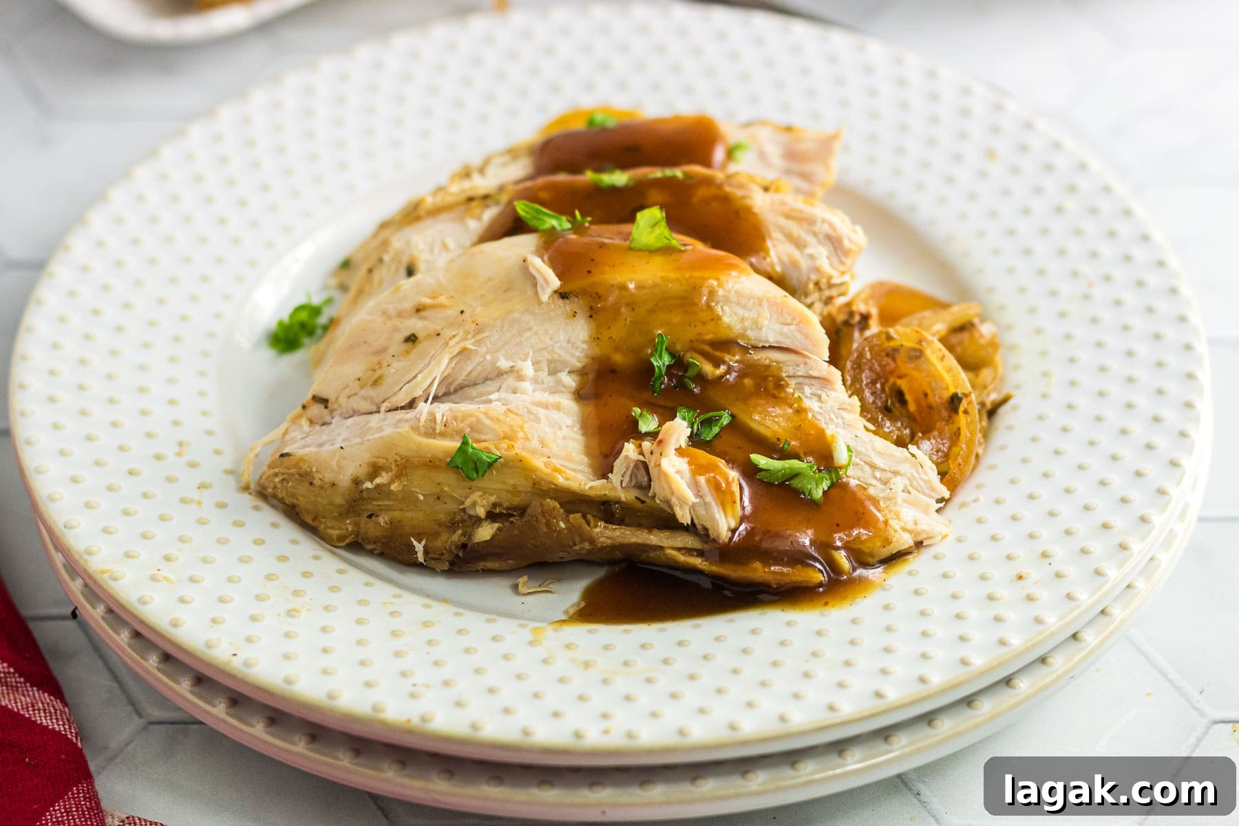 Chipotle Citrus Turkey Breast Slow Cooker Recipe 4 Closeup of slices of turkey breast covered in sauce on a white plate.