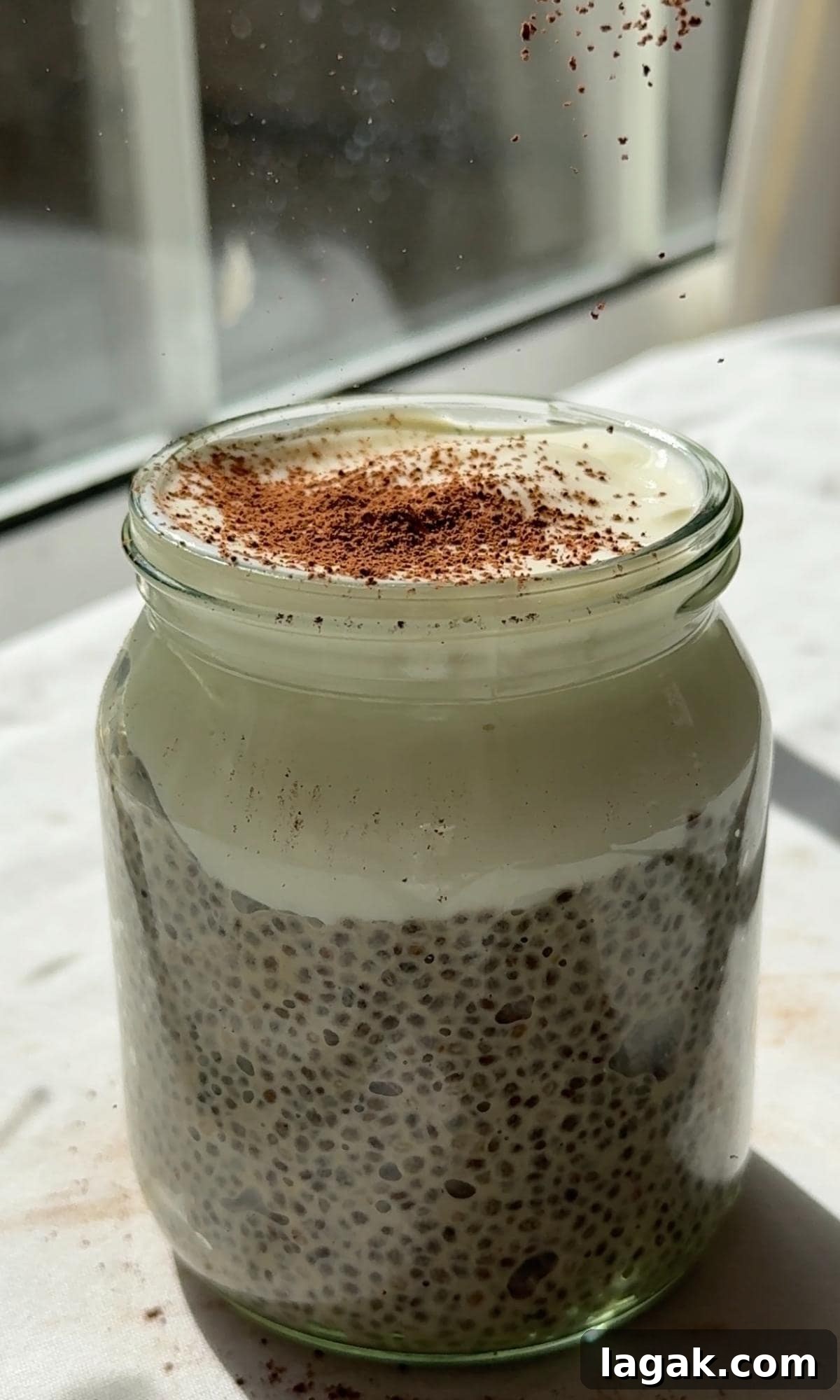 Tiramisu Chia Pudding with Creamy Yogurt — Quick Recipe 9 dusting cocoa powder over chia pudding with yogurt.