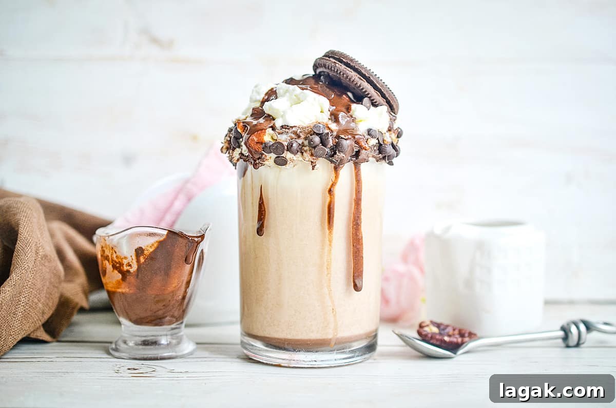 27 Cozy Fall Desserts That Taste Like Brown Sugar, Butter, and Memories 11 Cookie Dough Milkshake with a spoon and syrup in the background.