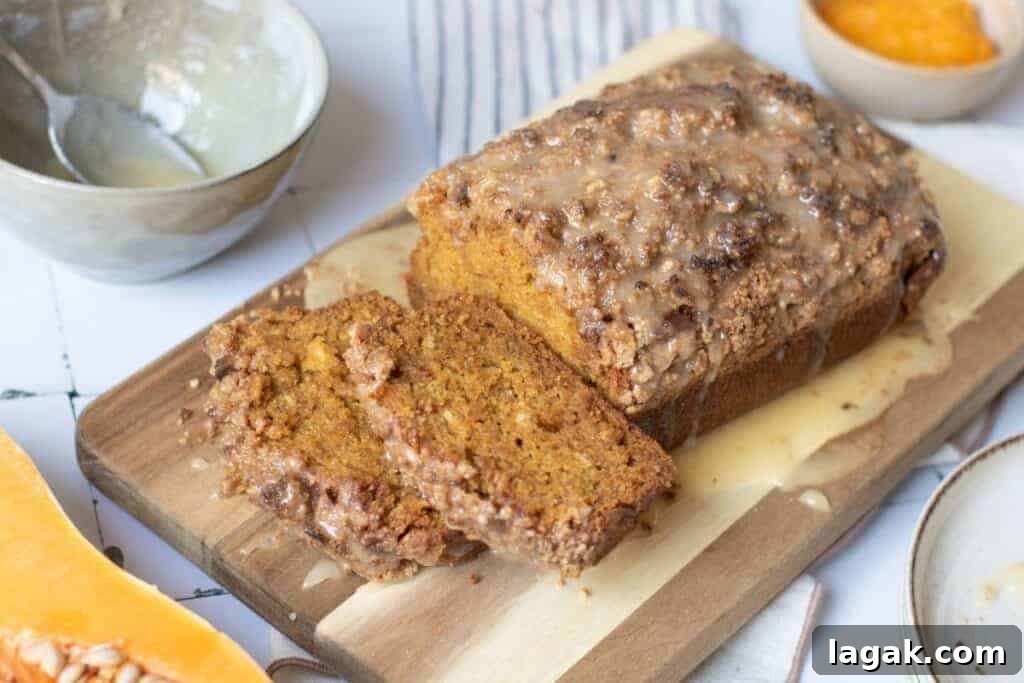 27 Cozy Fall Desserts That Taste Like Brown Sugar, Butter, and Memories 3 A loaf of glazed pumpkin bread with two slices cut sits on a wooden cutting board, surrounded by bowls containing glaze and orange puree.