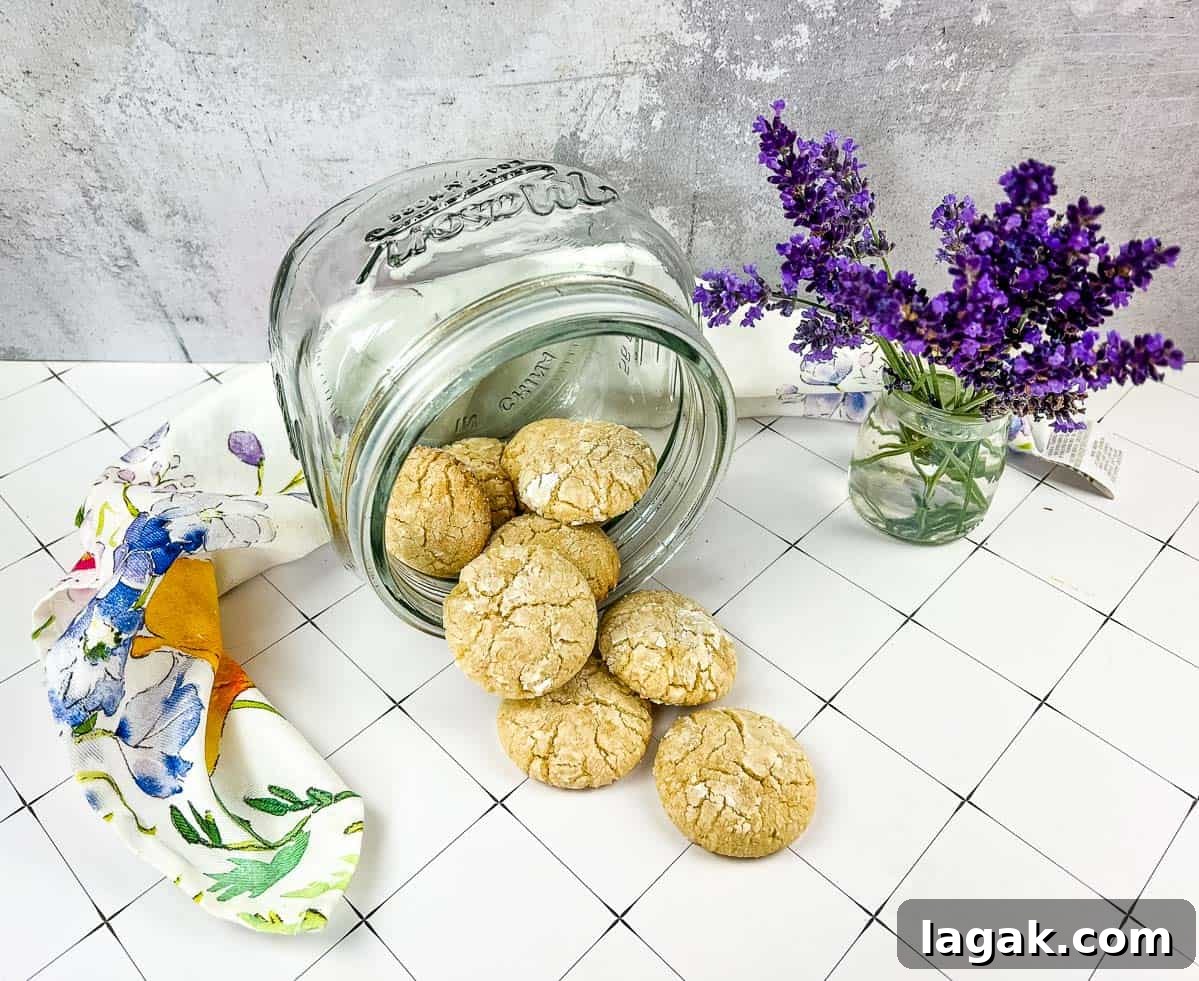 27 Cozy Fall Desserts That Taste Like Brown Sugar, Butter, and Memories 22 A jar of White Chocolate Crinkle Cookies next to lavender flowers.
