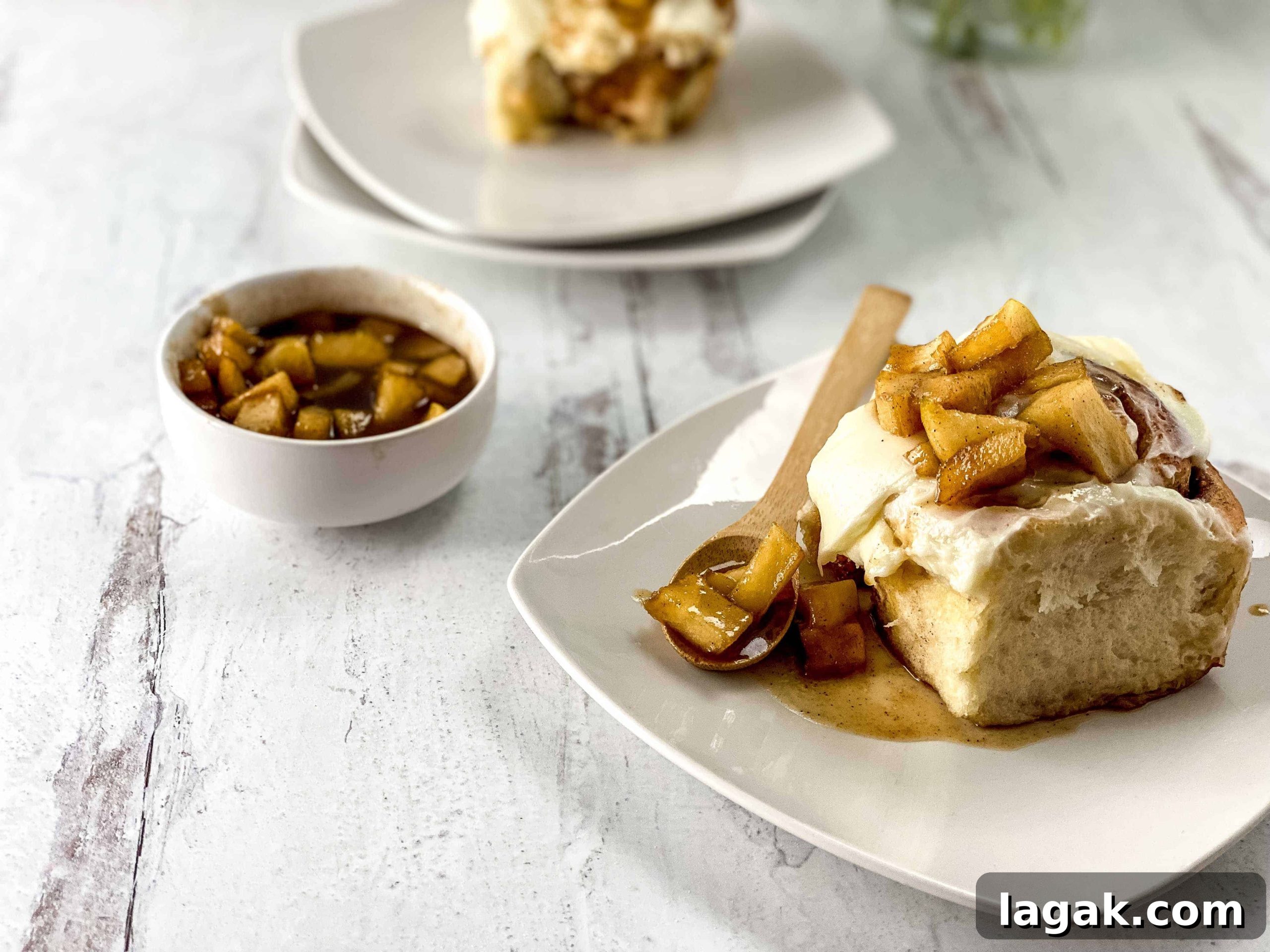27 Cozy Fall Desserts That Taste Like Brown Sugar, Butter, and Memories 29 An apple cinnamon roll on a plate with a spoon.