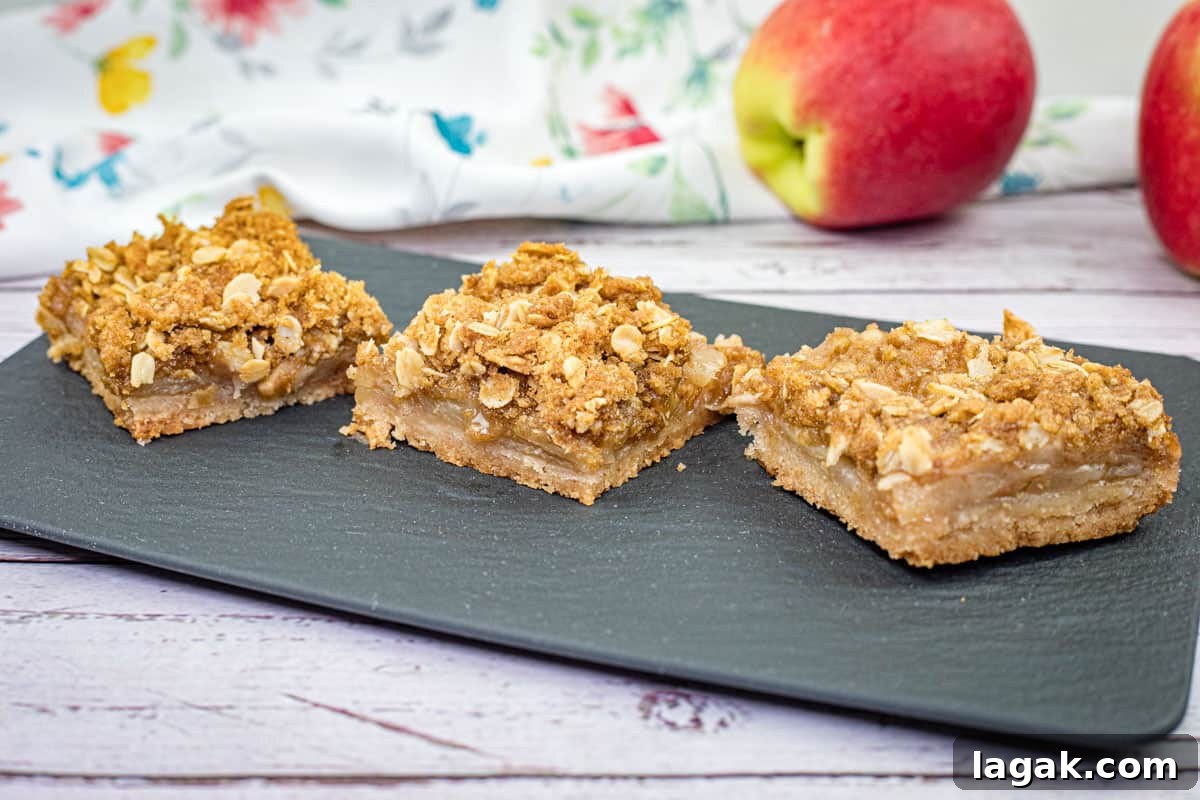 27 Cozy Fall Desserts That Taste Like Brown Sugar, Butter, and Memories 7 Three pieces of Dutch Apple Pie Squares on a black slate plate.