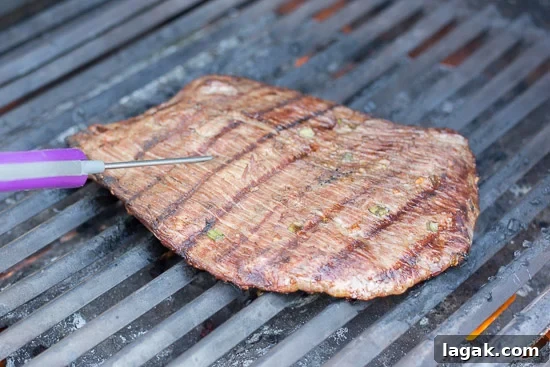 Asian-Inspired Gluten-Free Steak Marinade Recipe for Bold Flavor 5 Checking the temp on gluten free flank steak on the grill.