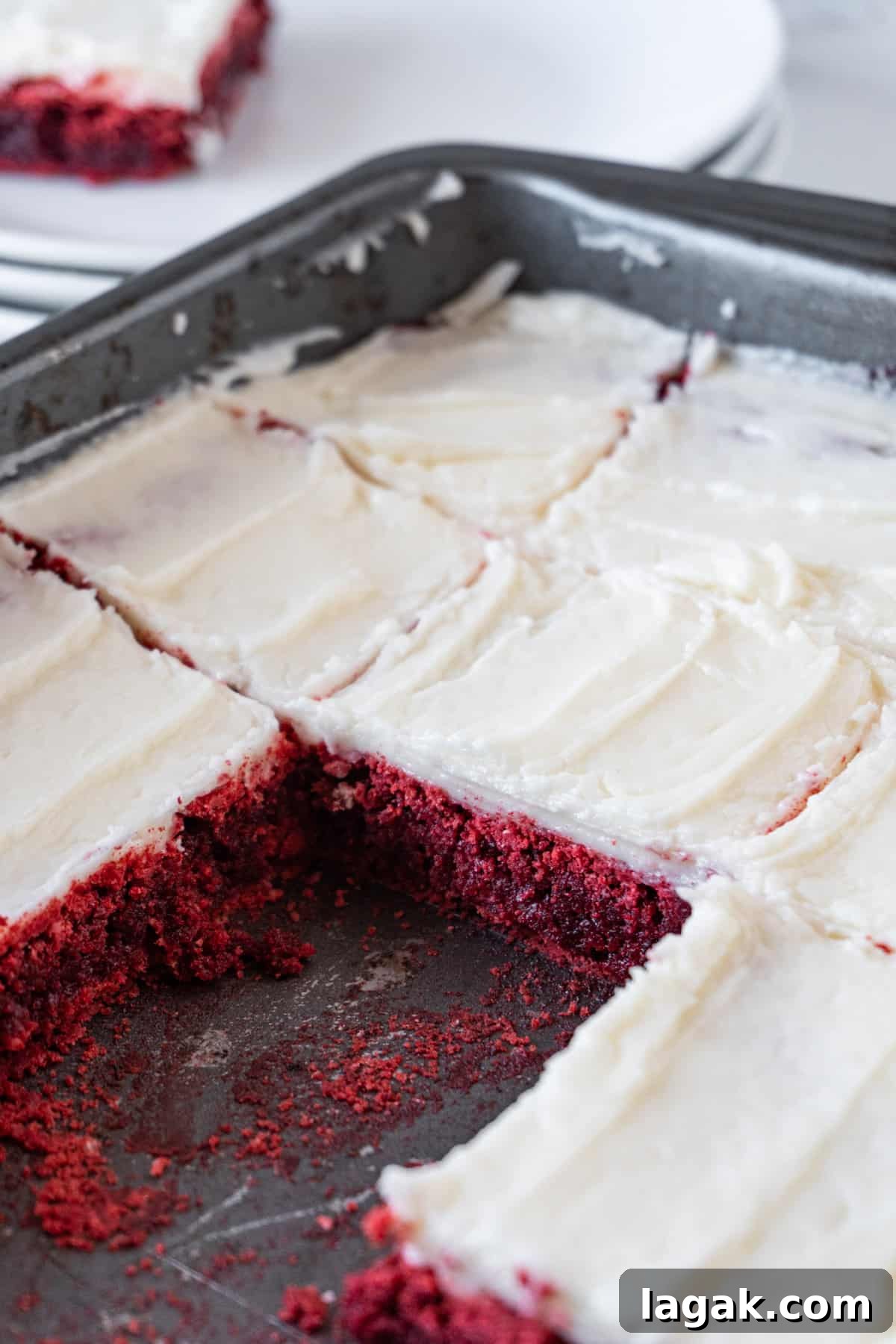 Red Velvet Brownies Recipe with Cream Cheese Swirl 4 red velvet brownies with cream cheese frosting in pan cut into squares.