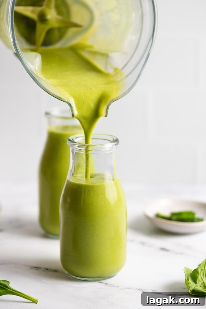 Top Vegetables to Add to Your Smoothies for Flavor & Nutrition 3 Pouring a green mango smoothie from a blender into a small jar.
