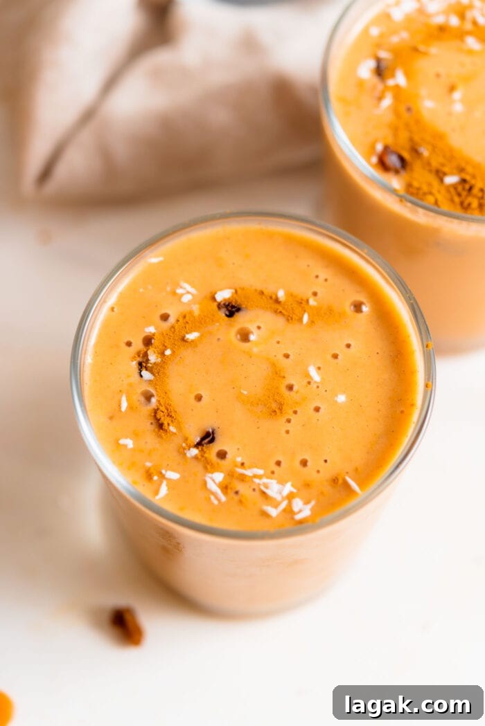 Top Vegetables to Add to Your Smoothies for Flavor & Nutrition 6 Creamy carrot smoothie in a glass topped with a few raisins and a sprinkle of coconut.