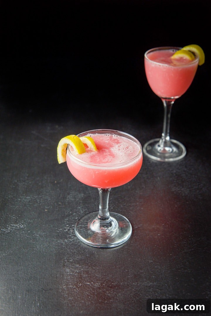 Pink Lady Cocktail Recipe: Classic Gin & Apple Cider Drink 2 The pink cocktail in a coupe and martini glass with lemon twists as garnish