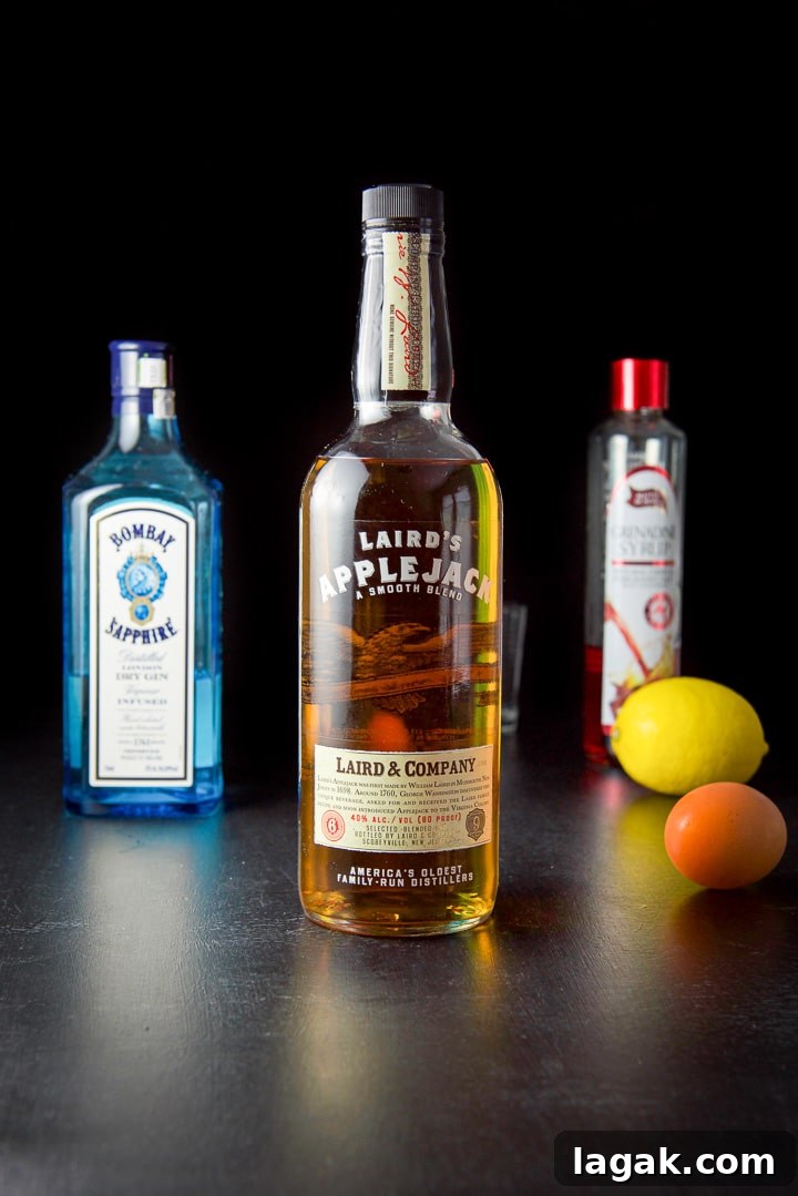 Pink Lady Cocktail Recipe: Classic Gin & Apple Cider Drink 4 AppleJack liquor, gin, grenadine, lemon and egg on the black table