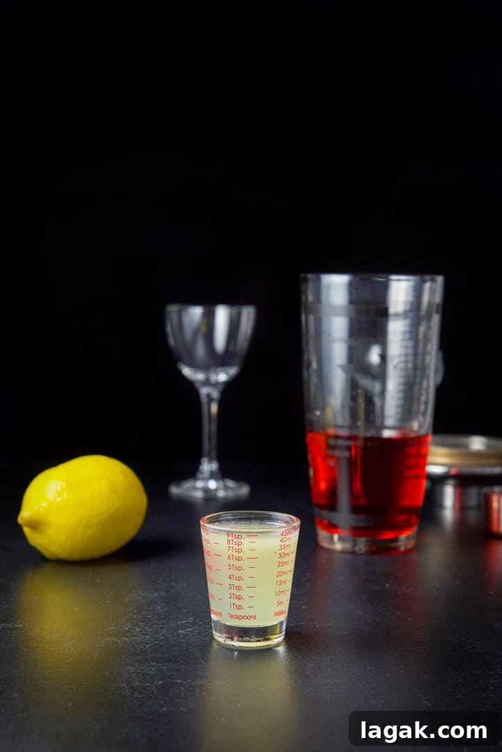 Pink Lady Cocktail Recipe: Classic Gin & Apple Cider Drink 8 Lemon juice measured out with the lemon, shaker and glass on the table