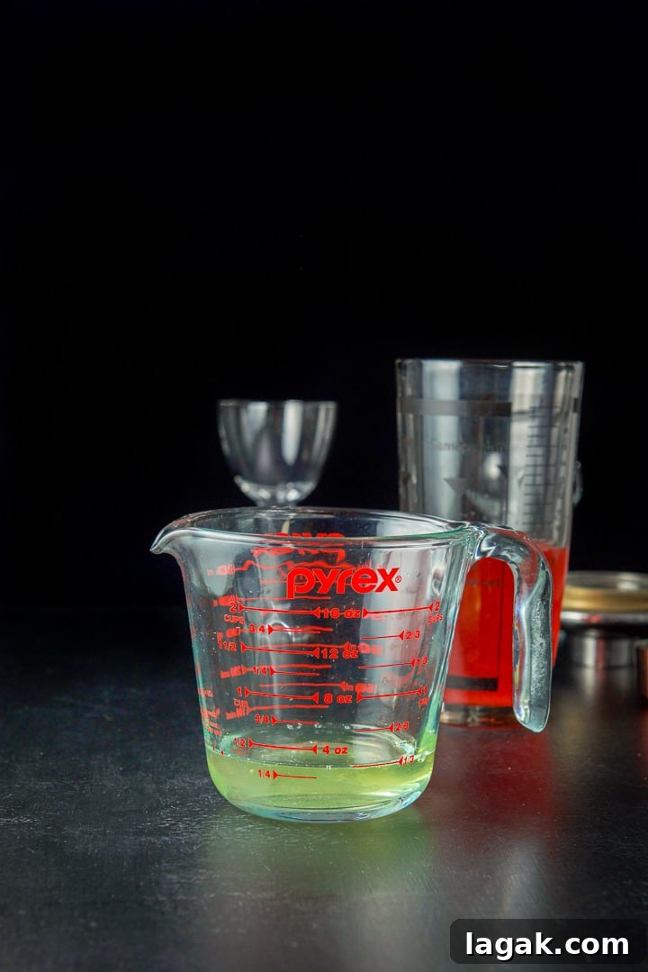Pink Lady Cocktail Recipe: Classic Gin & Apple Cider Drink 9 Egg white in a measuring glass with the shaker in the background