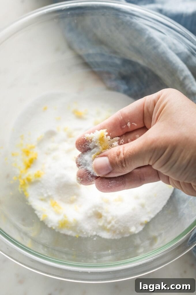 Lemon Olive Oil Zucchini Muffins with Light Citrus Glaze 4 A hand rubbing sugar and lemon zest between the fingers and thumb to infuse the sugar with lemon flavor.