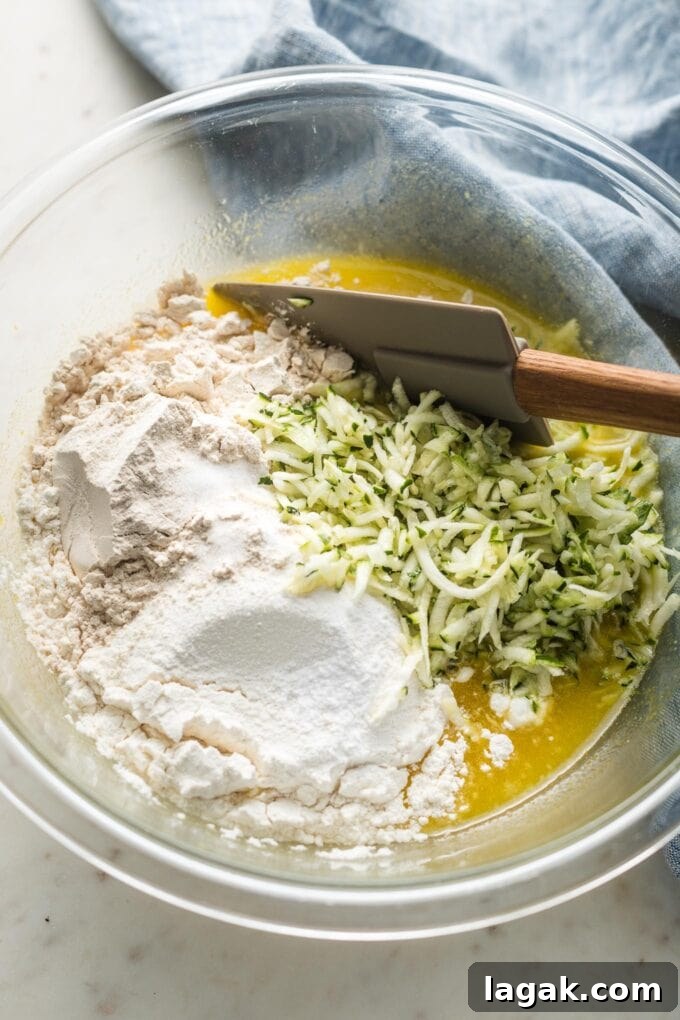 Lemon Olive Oil Zucchini Muffins with Light Citrus Glaze 5 Prep bowl with egg mixture, flour, and grated zucchini.