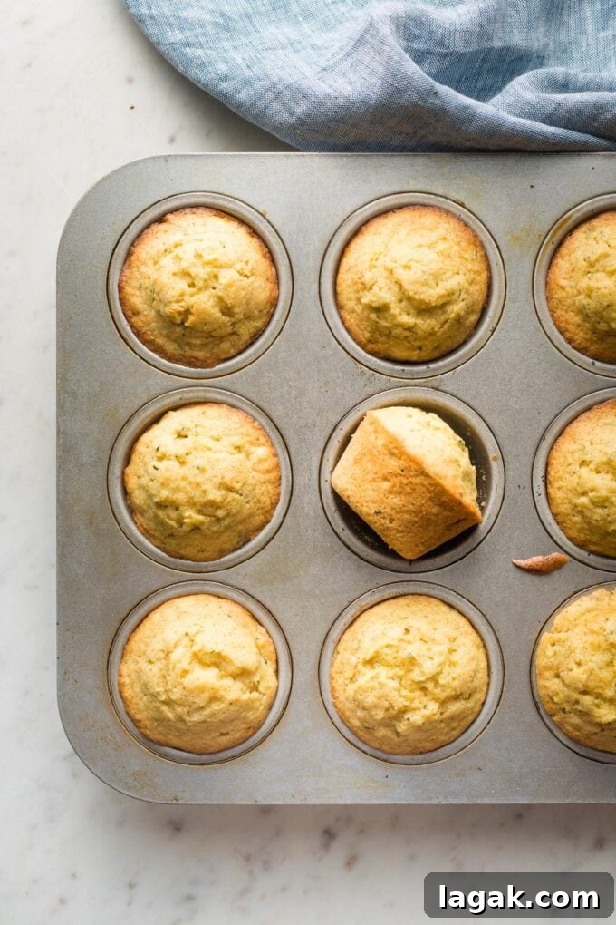 Lemon Olive Oil Zucchini Muffins with Light Citrus Glaze 8 Baked muffins in a tin.