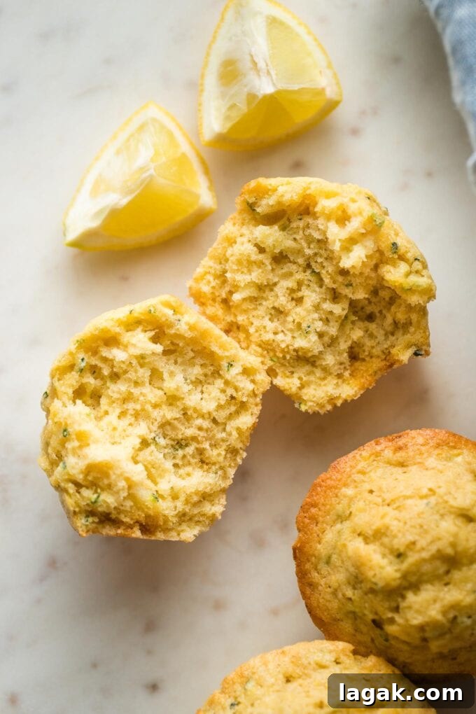 Lemon Olive Oil Zucchini Muffins with Light Citrus Glaze 9 Close up of a lemon zucchini muffin split open to reveal the moist crumb and tender texture.
