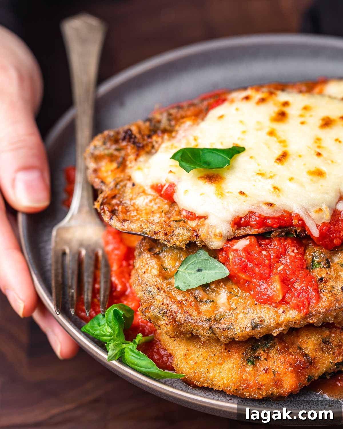 Chicken and Eggplant Parmesan Recipe: Crispy Baked Italian Casserole 9 Close up shot of chicken eggplant parm held in hands.