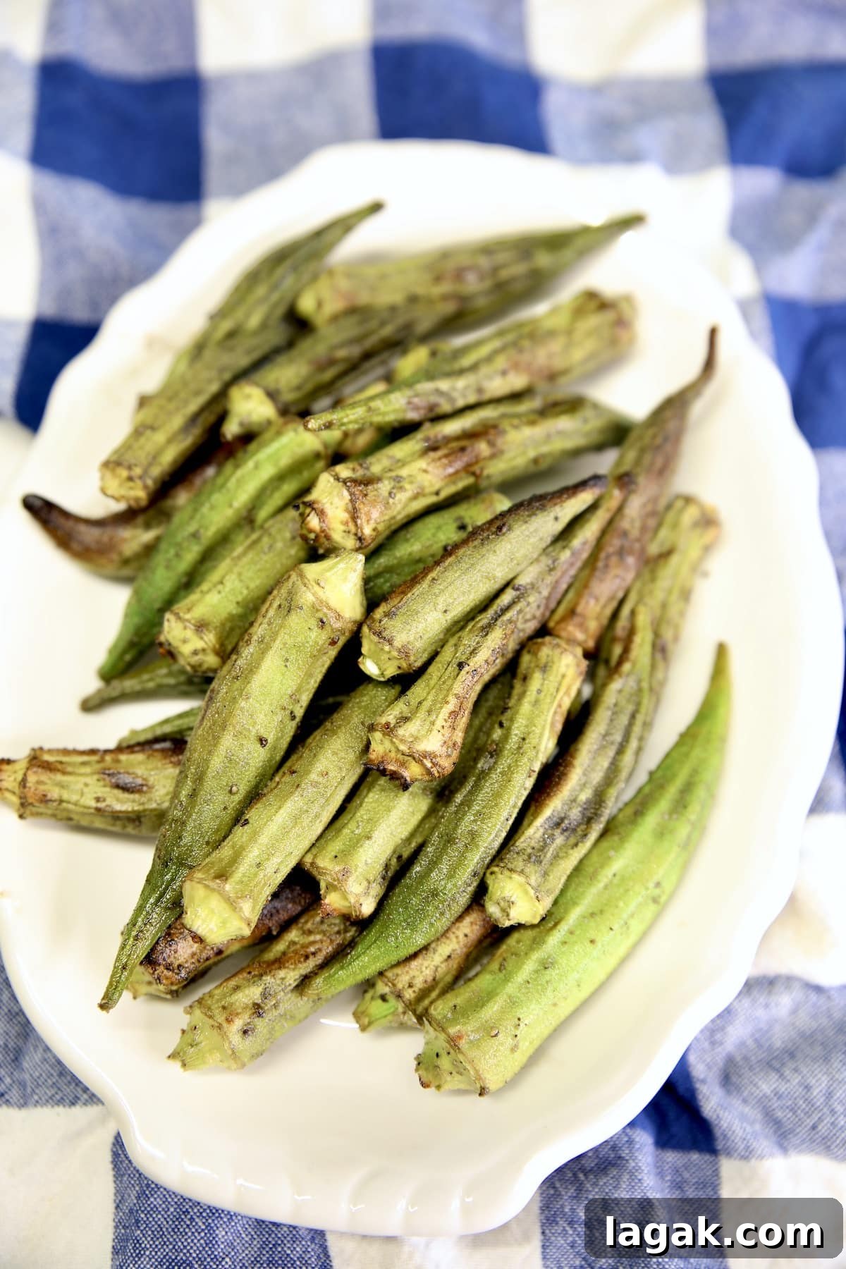 Easy grilled okra recipe. Platter of grilled okra on a blue check napkin.