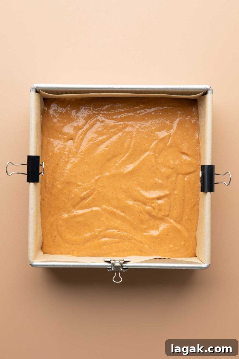 pumpkin cake batter in square baking pan