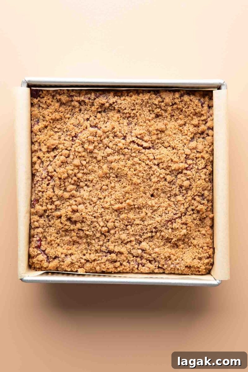 baked pumpkin cranberry sauce coffee cake in parchment paper lined square baking pan