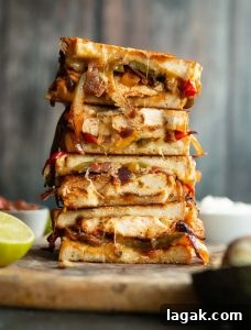 Chicken Fajita Grilled Cheese 4 sandwich halves stack on each other with filling spilling out on wooden board