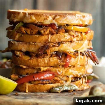 Chicken Fajita Grilled Cheese Sandwich — Sizzling Tex‑Mex Melt 2 3 sandwiches stacked on each other with filling spilling out on wooden board