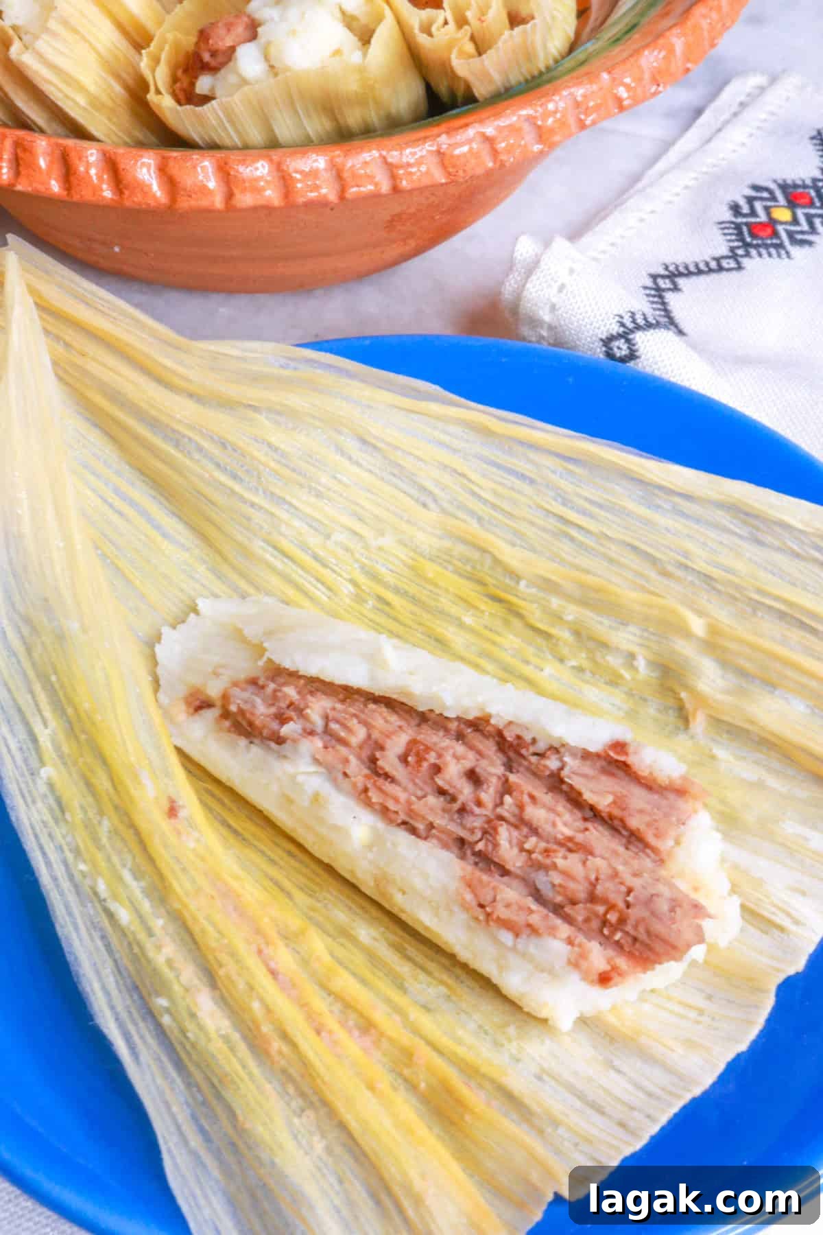 Refried Bean Tamales Recipe – Authentic Mexican Tamales 15 Tamales de Frijol, with a close-up of one open bean tamal on a blue plate
