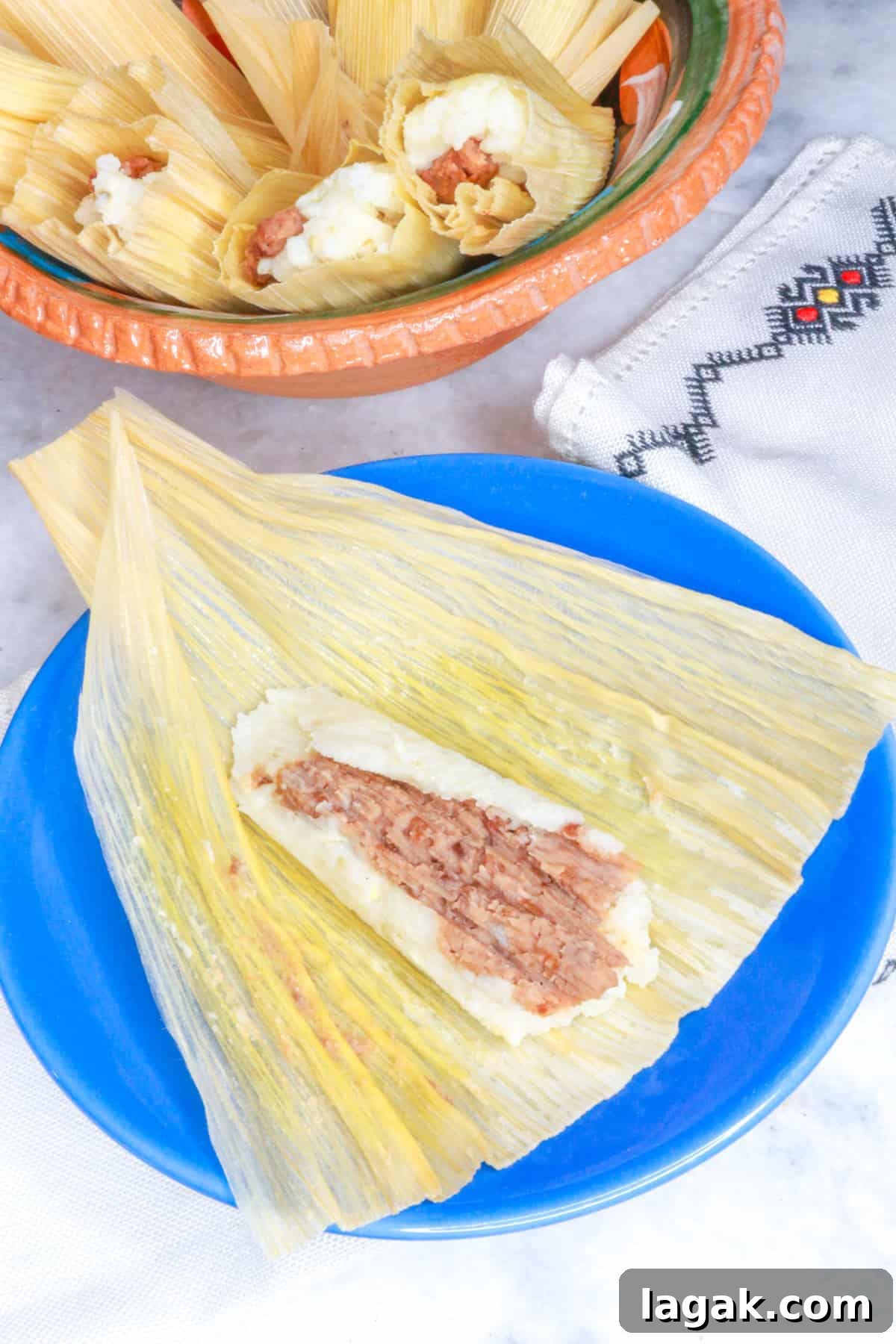 Refried Bean Tamales Recipe – Authentic Mexican Tamales 2 Tamales de Frijol, with one open bean tamal on a blue plate