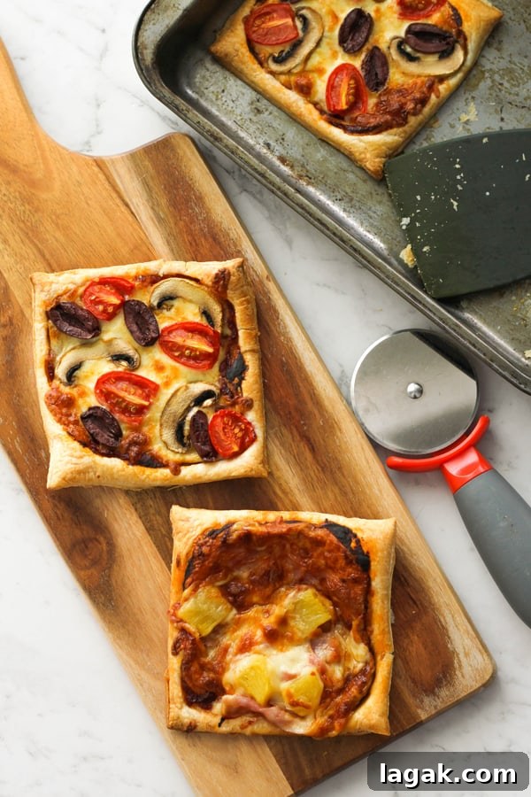 Crispy Puff Pastry Pizza Recipe — Quick Homemade Pizzas 2 puff pastry pizzas on a wooden board.