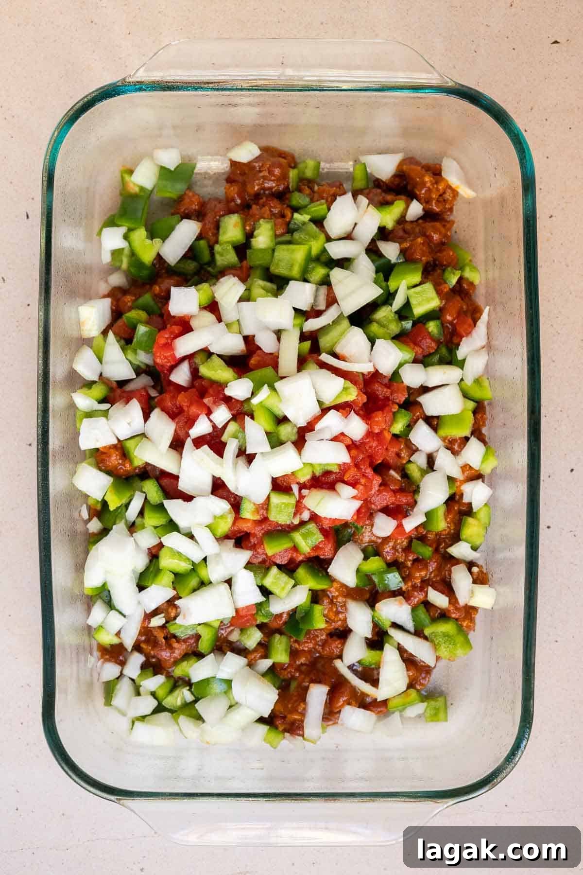 The canned chili and diced veggies are added directly to a 9 by 13 inch baking dish.
