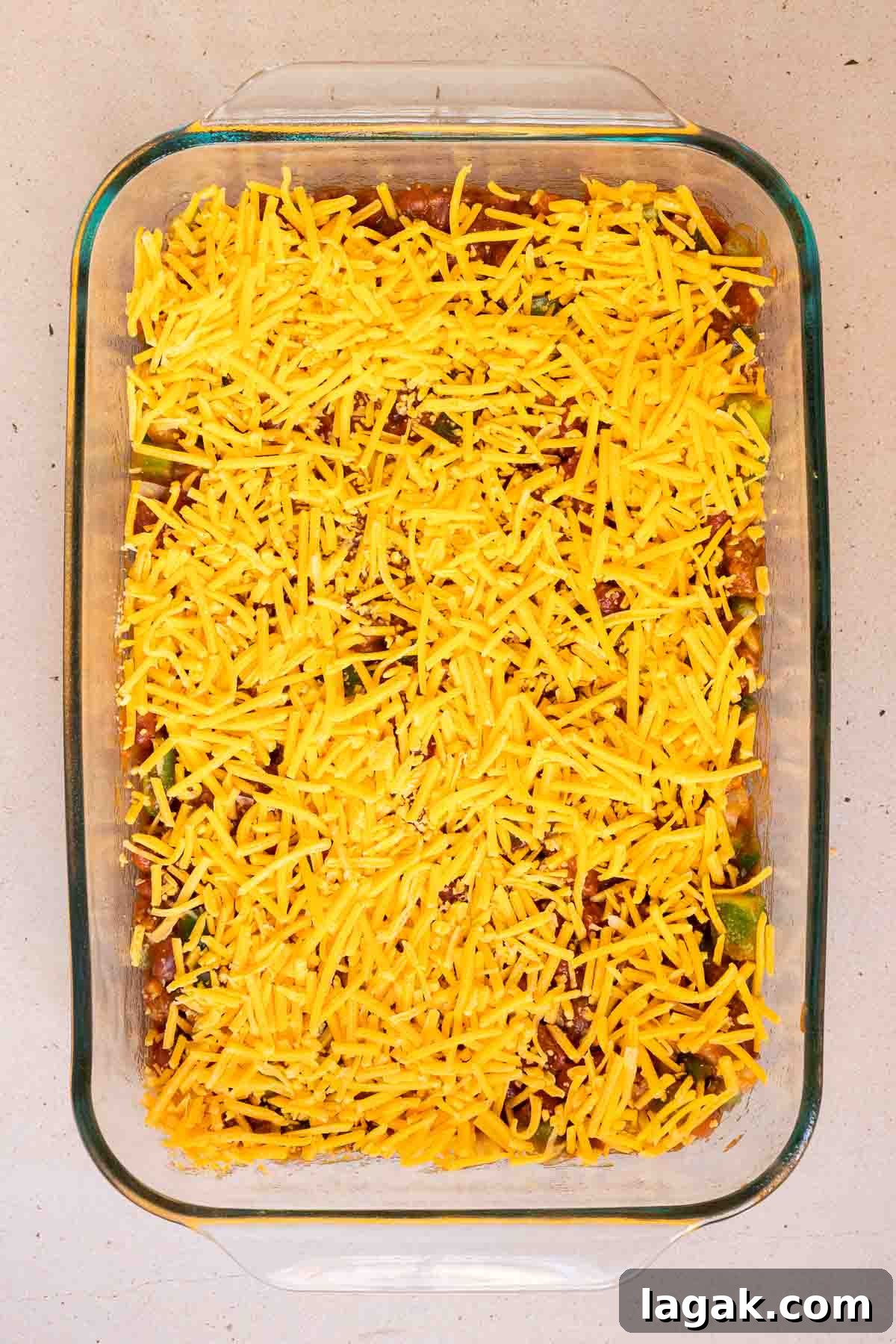 Shredded cheddar is sprinkled evenly over the chili.