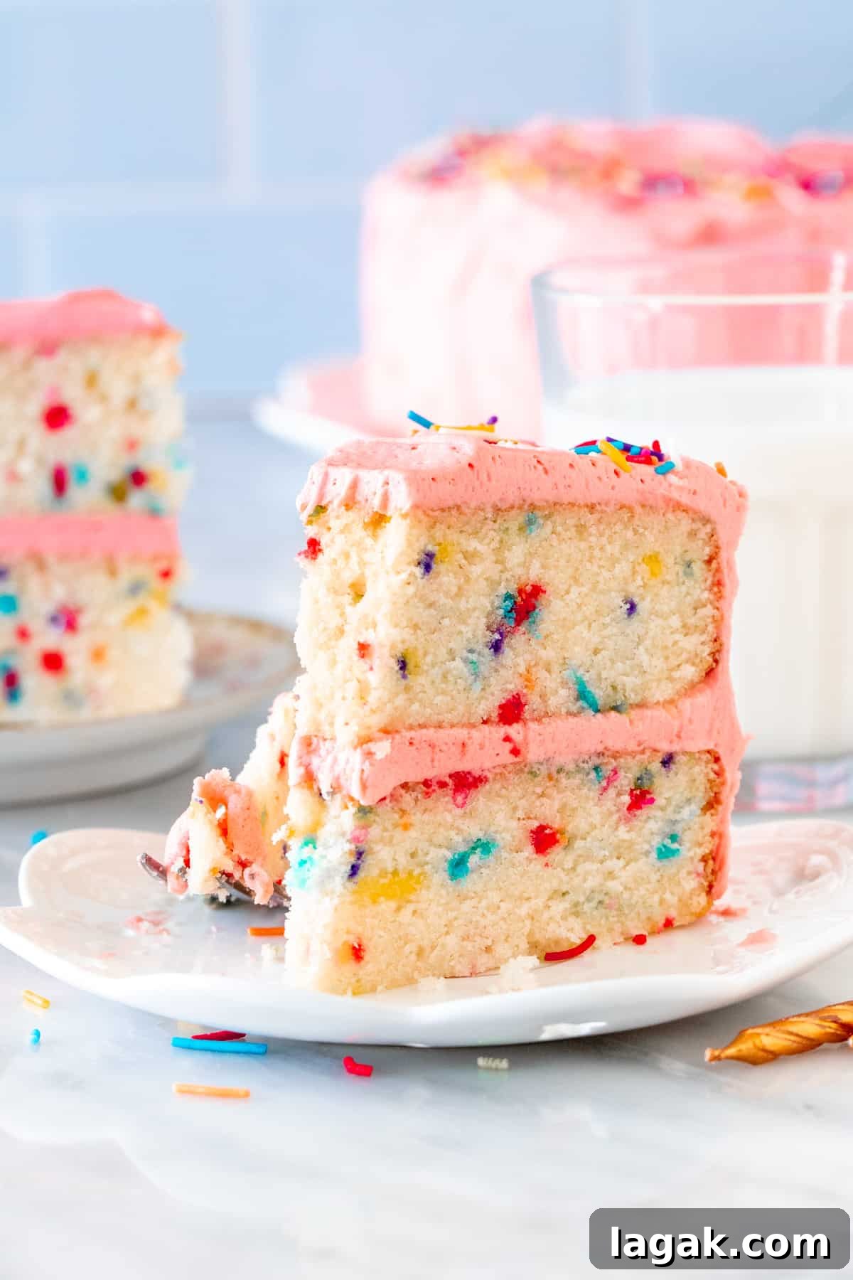 Funfetti Cake from Scratch Filled with Sprinkles 6 Slice of sprinkle cake with pink frosting