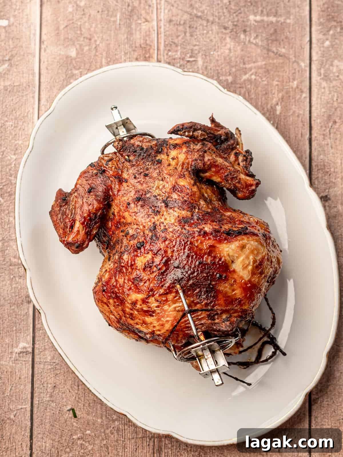 Cooked rotisserie chicken on a white platter.