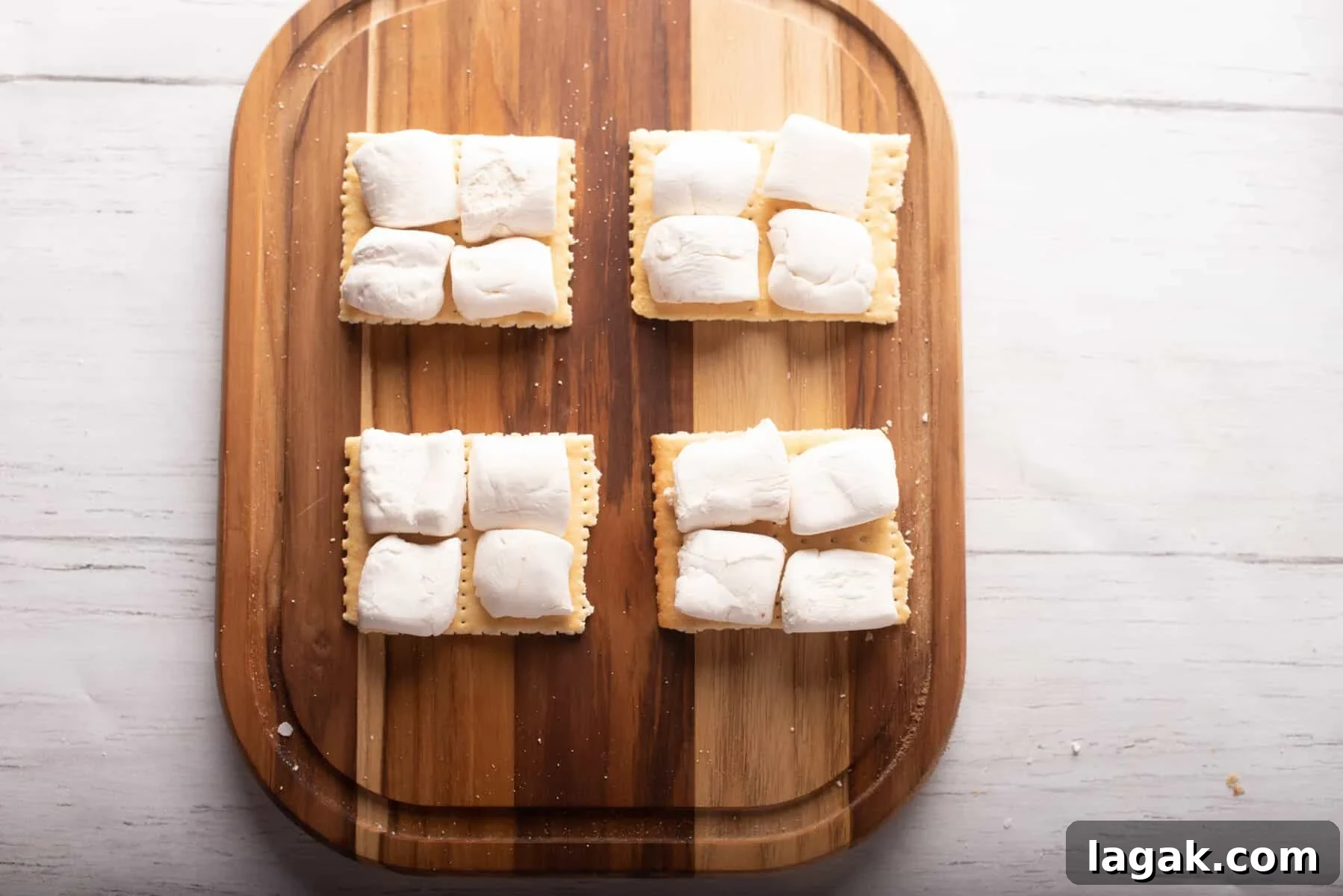 Air Fryer S'mores: Quick Indoor Campfire Dessert Recipe 4 Overhead view of marshmallows cut in half and placed above the wooden board.