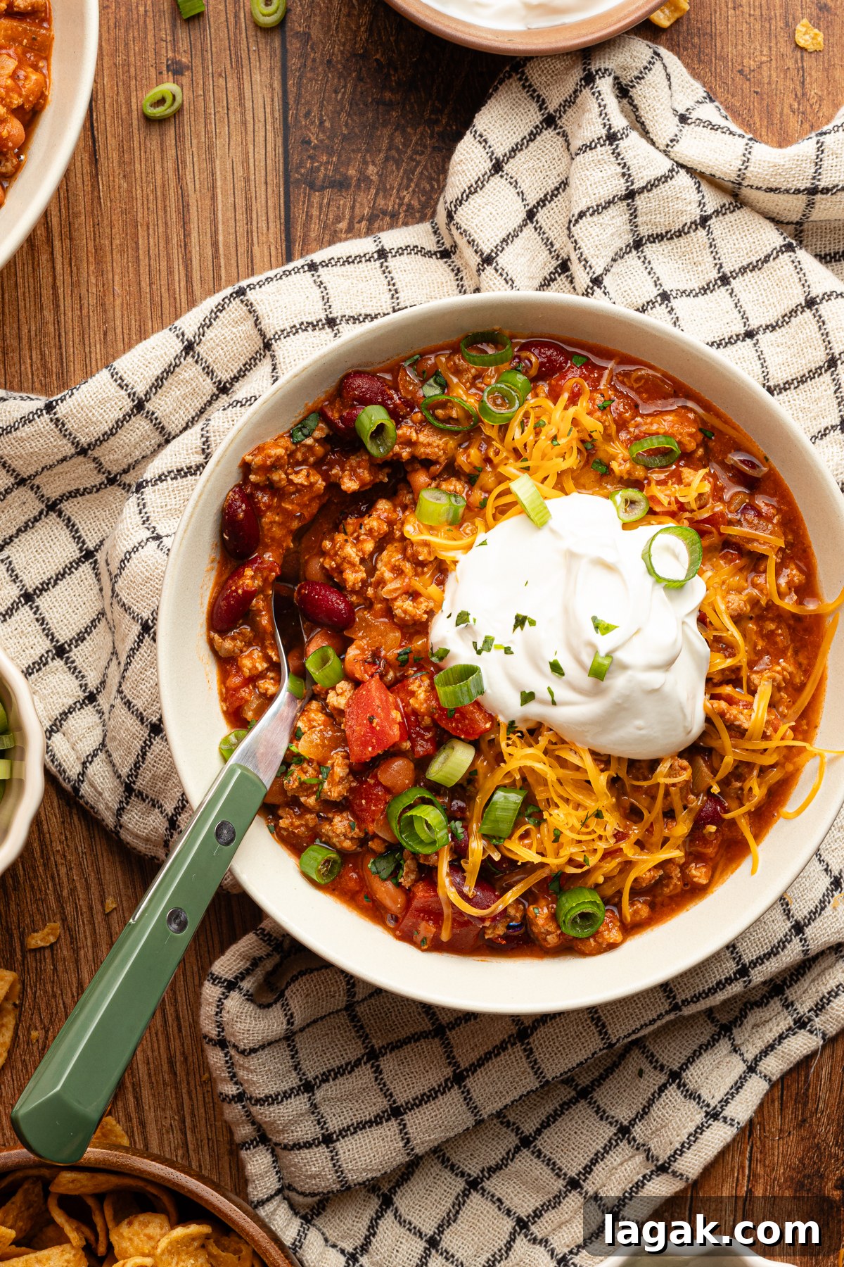 30-Minute High-Protein Turkey Chili Recipe 9 A small serving bowl filled with protein packed 30 minute turkey chili surrounded by a variety of topping ingredients