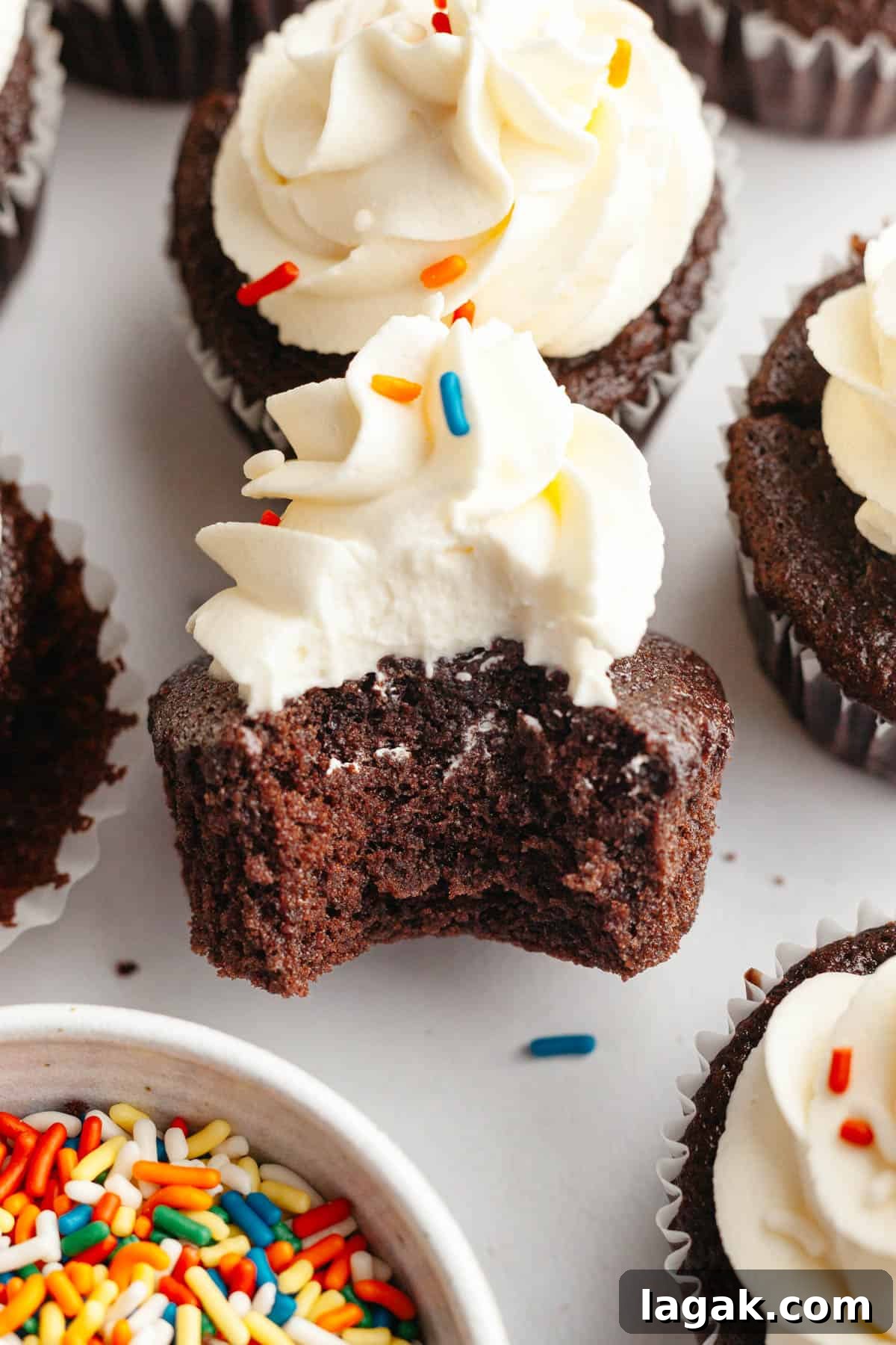 Moist Chocolate Cupcakes with Cream Cheese Frosting Recipe 11 A chocolate cupcake with frosting with a bite taken out of it.