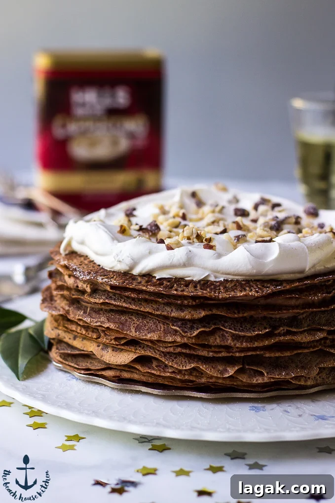 Double-Chocolate-Hazelnut-Crepe-Cake Double-Chocolate-Hazelnut-Crepe-Cake on white platter with coffee can in background.