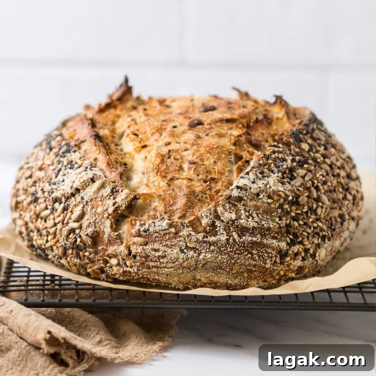 Multigrain Sourdough Bread: Step-by-Step Artisan Recipe 14 A loaf of multigrain sourdough bread on a parchment lined cooling rack.