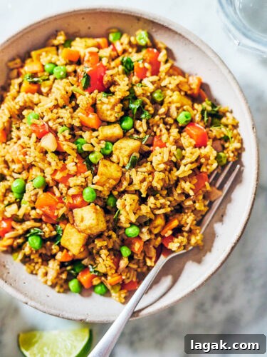 Thai Green Curry Fried Rice in a bowl with a fork.