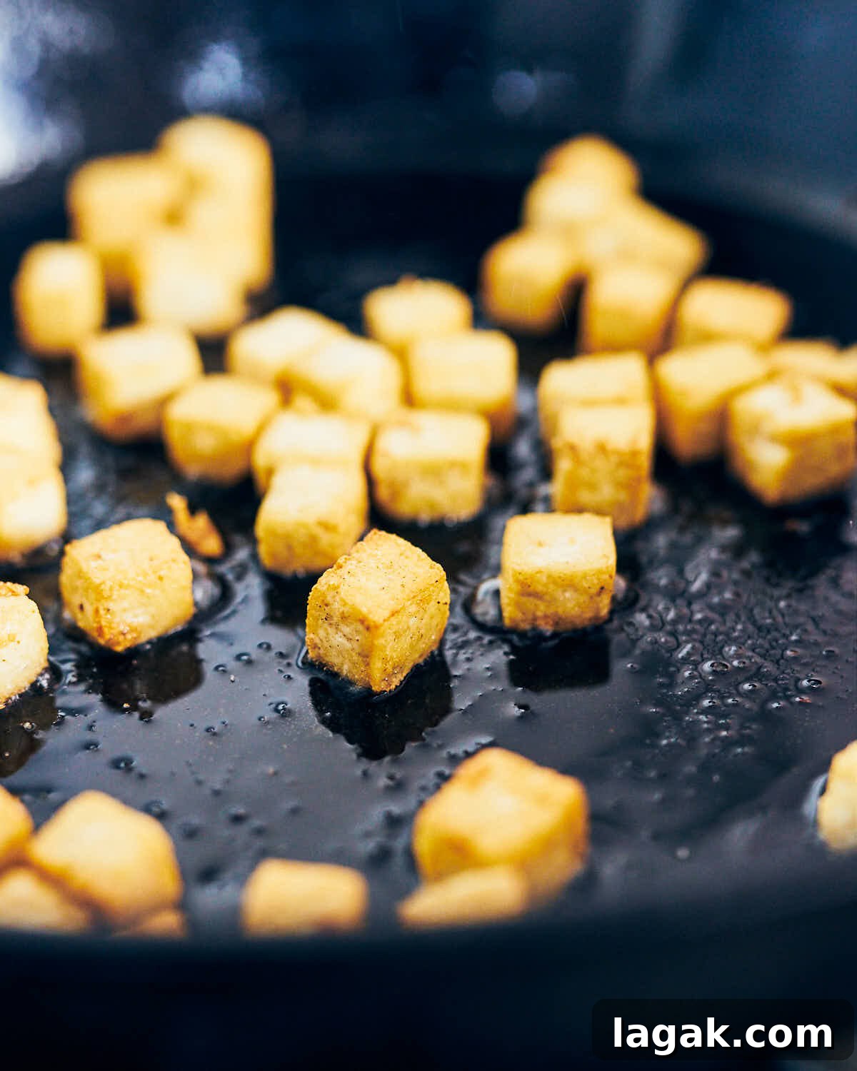 Sautéing tofu in a skillet for Thai Green Curry Fried Rice.