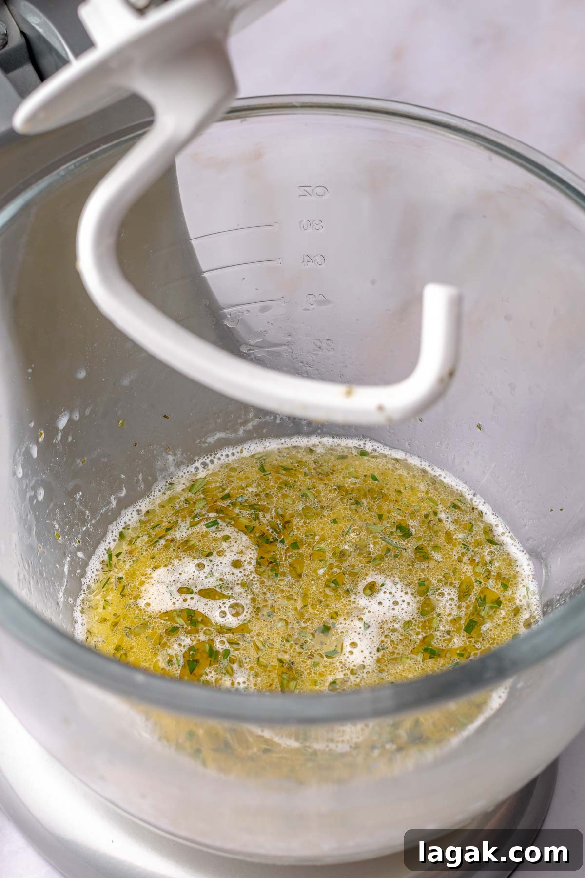 Savory Breakfast Rolls with Creamy Hollandaise Sauce 6 Wet ingredients for bread dough in a bowl with a dough hook.