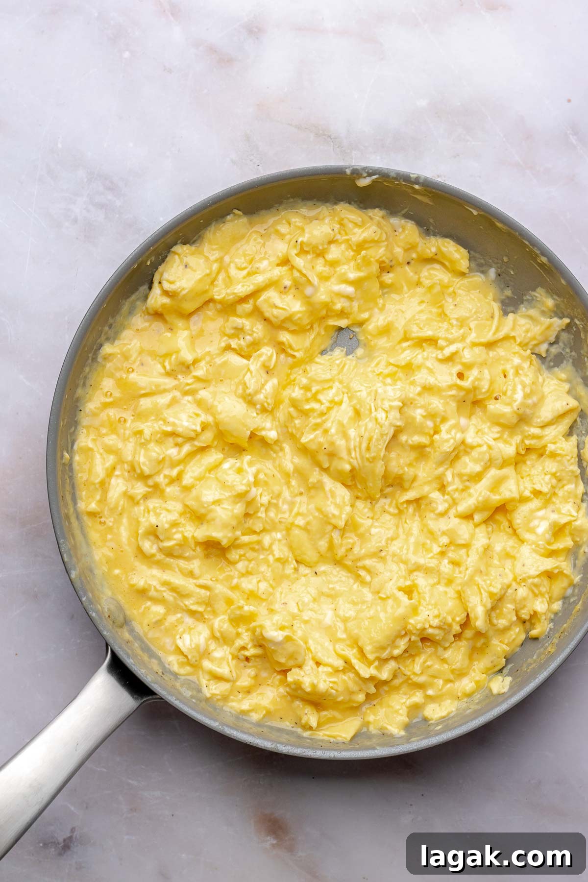 Savory Breakfast Rolls with Creamy Hollandaise Sauce 9 Scrambled eggs in a pan.