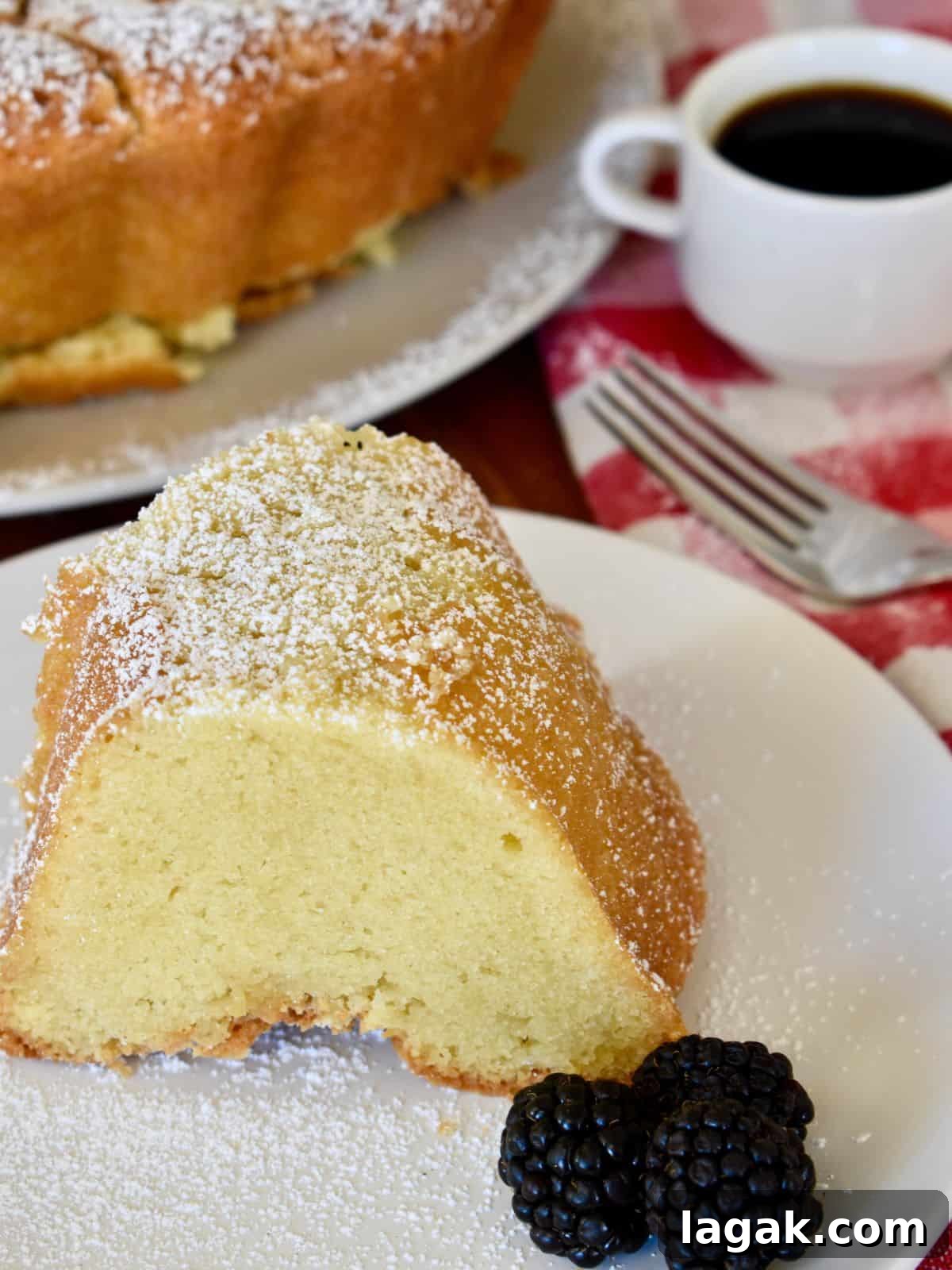 Mascarpone Pound Cake Recipe: Moist Italian Cream Cake with Mascarpone 2 Slice of mascarpone pound cake on a white plate with a fork behind it.