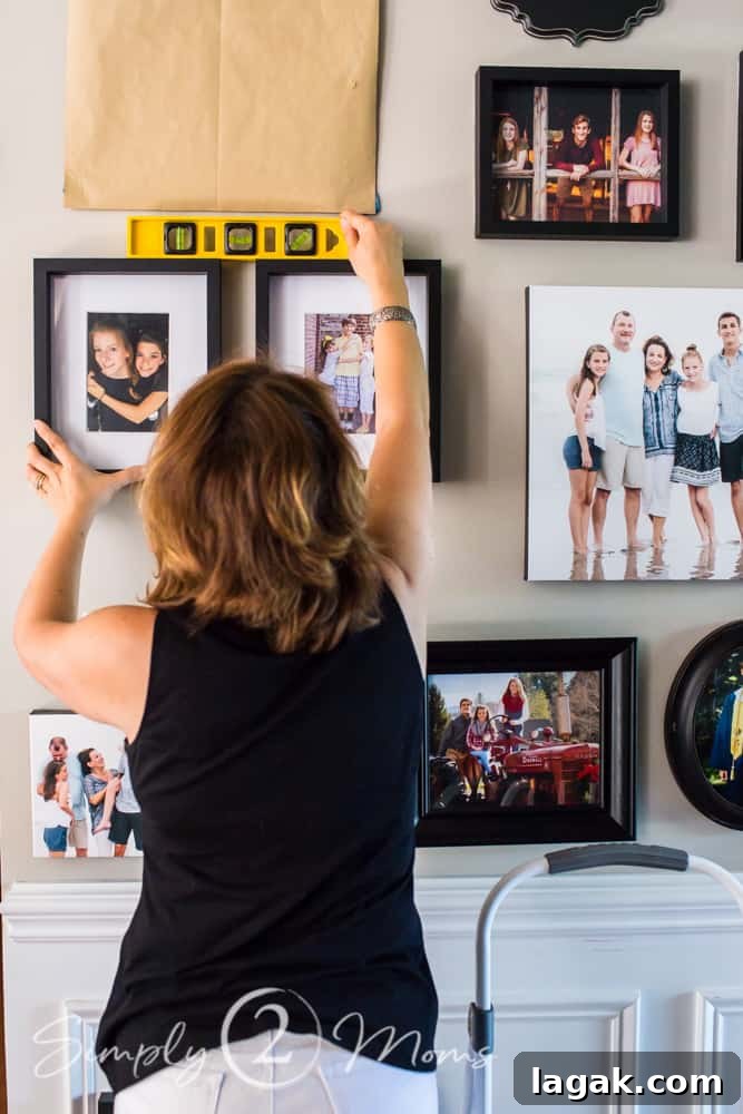 woman installing a gallery wall using a level